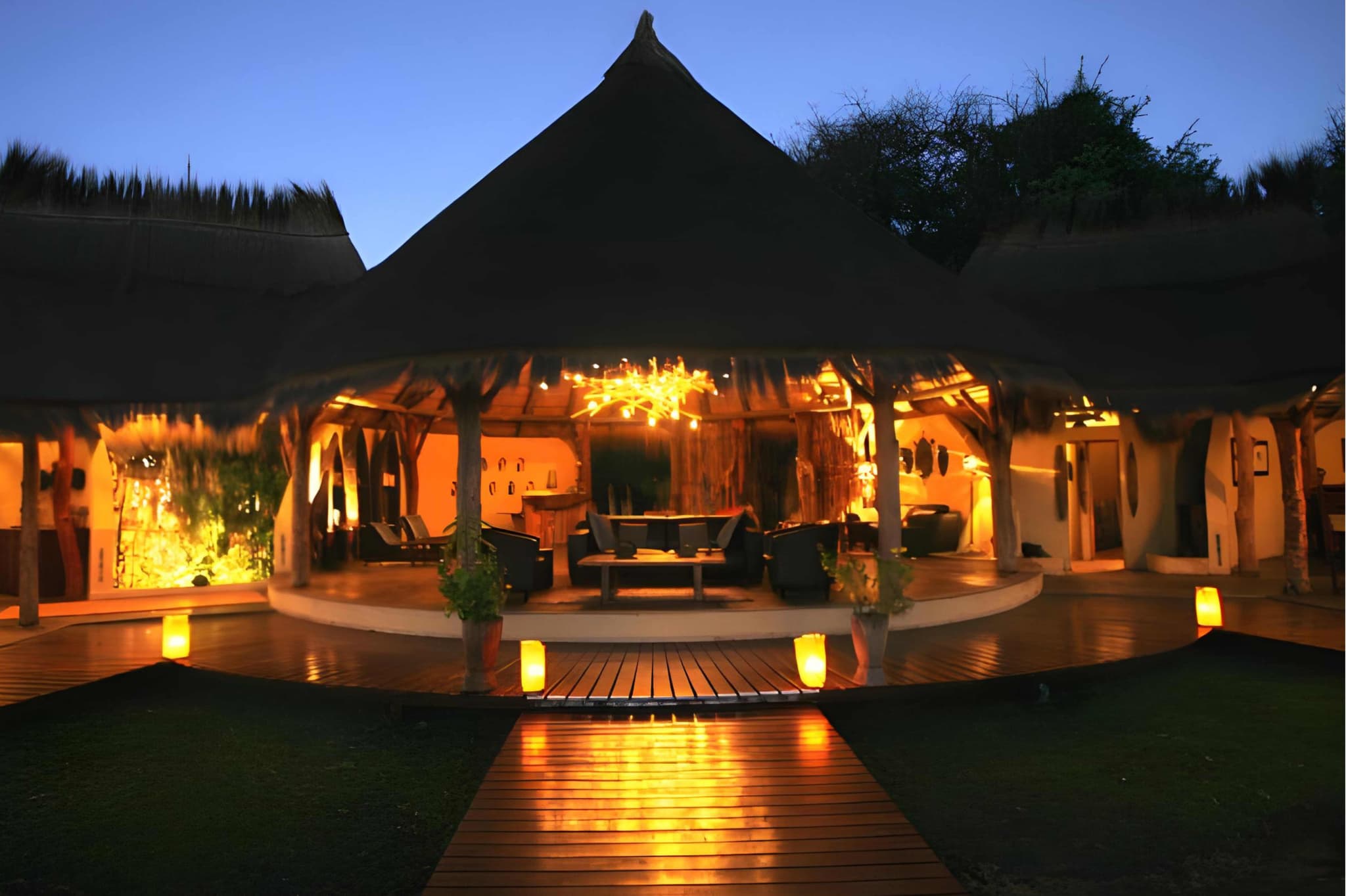 Camp Kwando Lodge at dusk with candlelit walkway